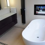 Aquavision Frameless waterproof Tv with black glass mounted in a bathroom