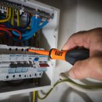 Klein Tools Promo image of someone using one of the insulated screwdrivers in a fuse box
