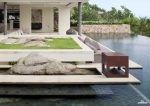 Garvan Loto Outdoor 360 Case Speaker SA117 in corten effect shown in a garden next to a pool